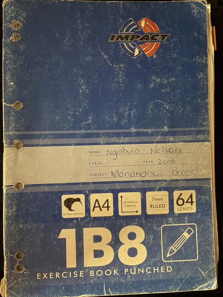 Worn blue A4 exercise book with a handwritten label: Name Ngahuia Nelson, Year 2006, Subject Manawanui Branch.