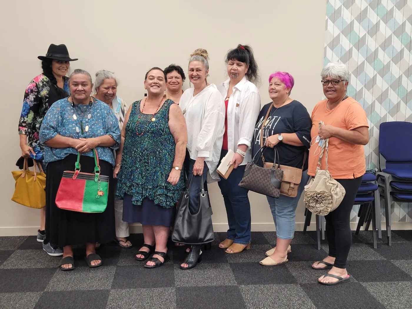 Nine women standing in a row, several holding the bags they swapped.