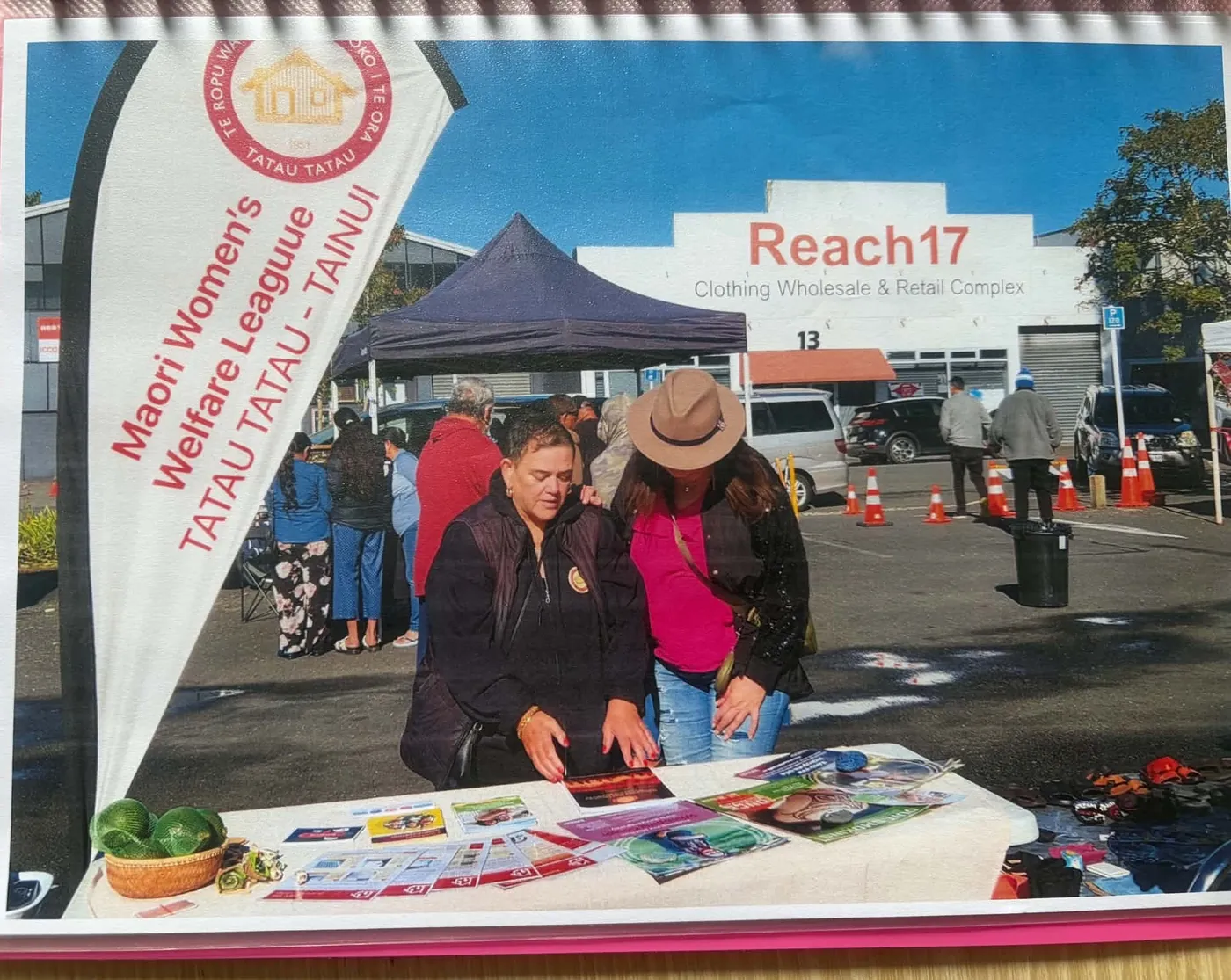 Two people at a market stall with a League banner and leaflets laid out on the table.
