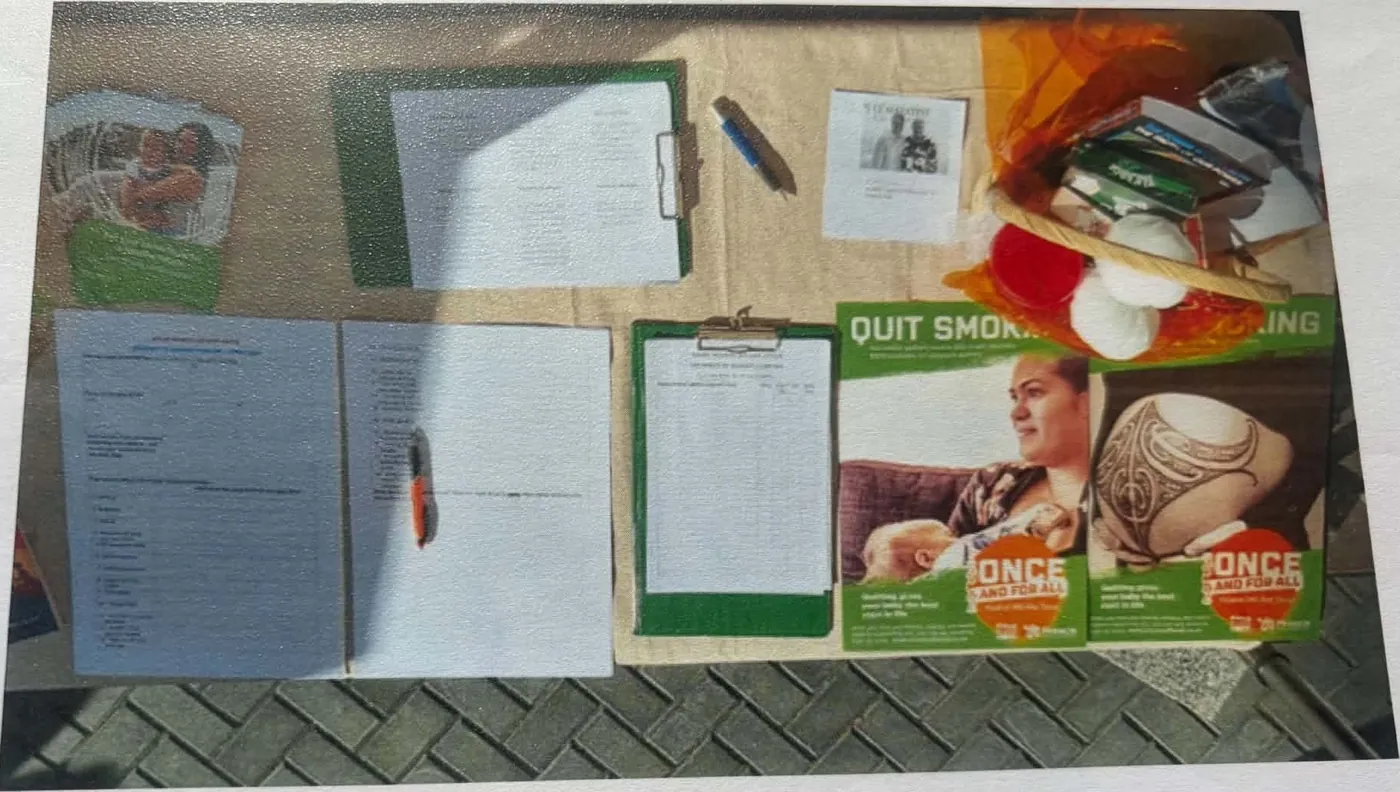 Overhead view of a table with clipboards and leaflets on quitting smoking and child immunisation.