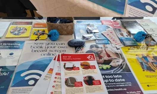 Table covered in health leaflets, including breast screening information.